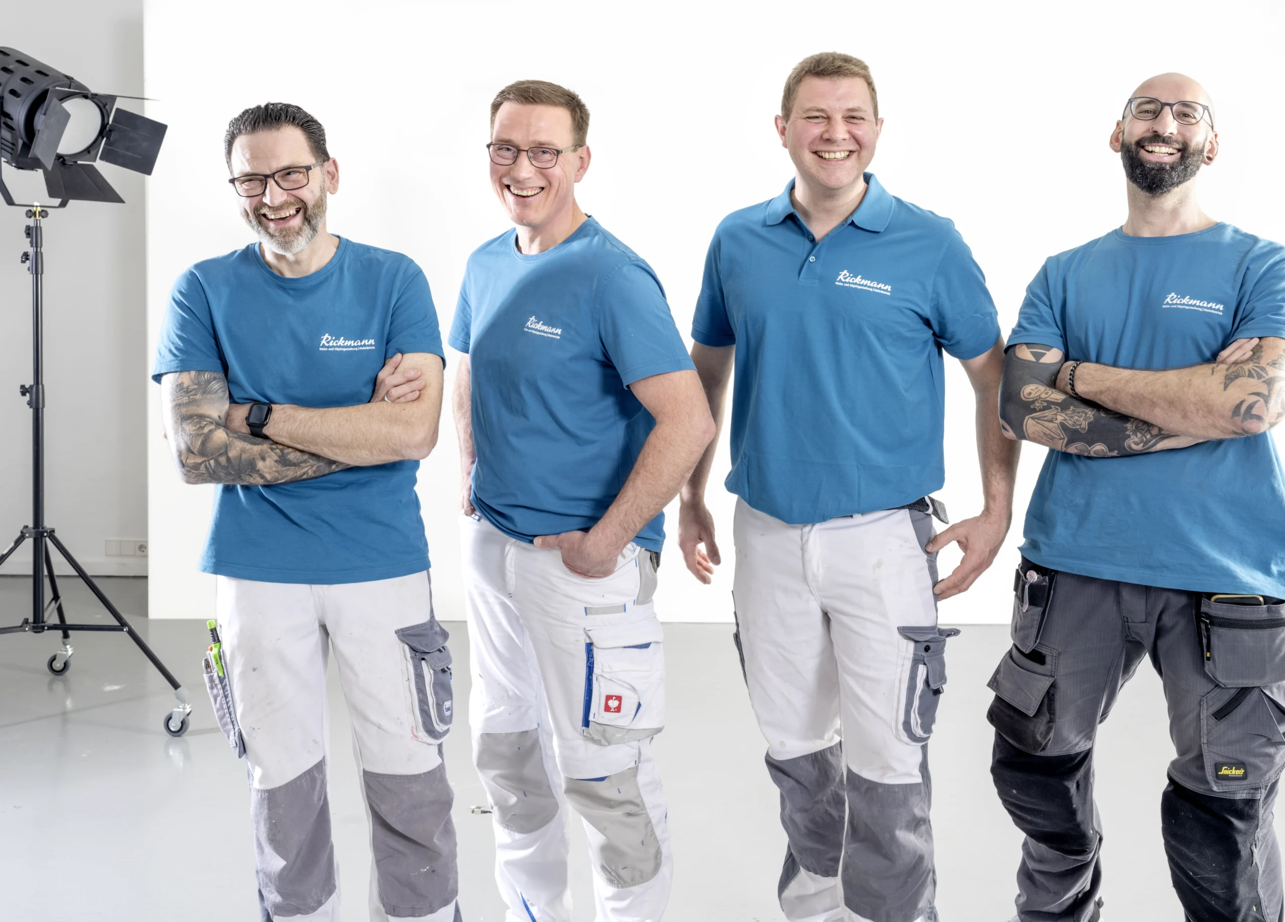 Drei Handwerker des Malerbetriebs in Arbeitskleidung