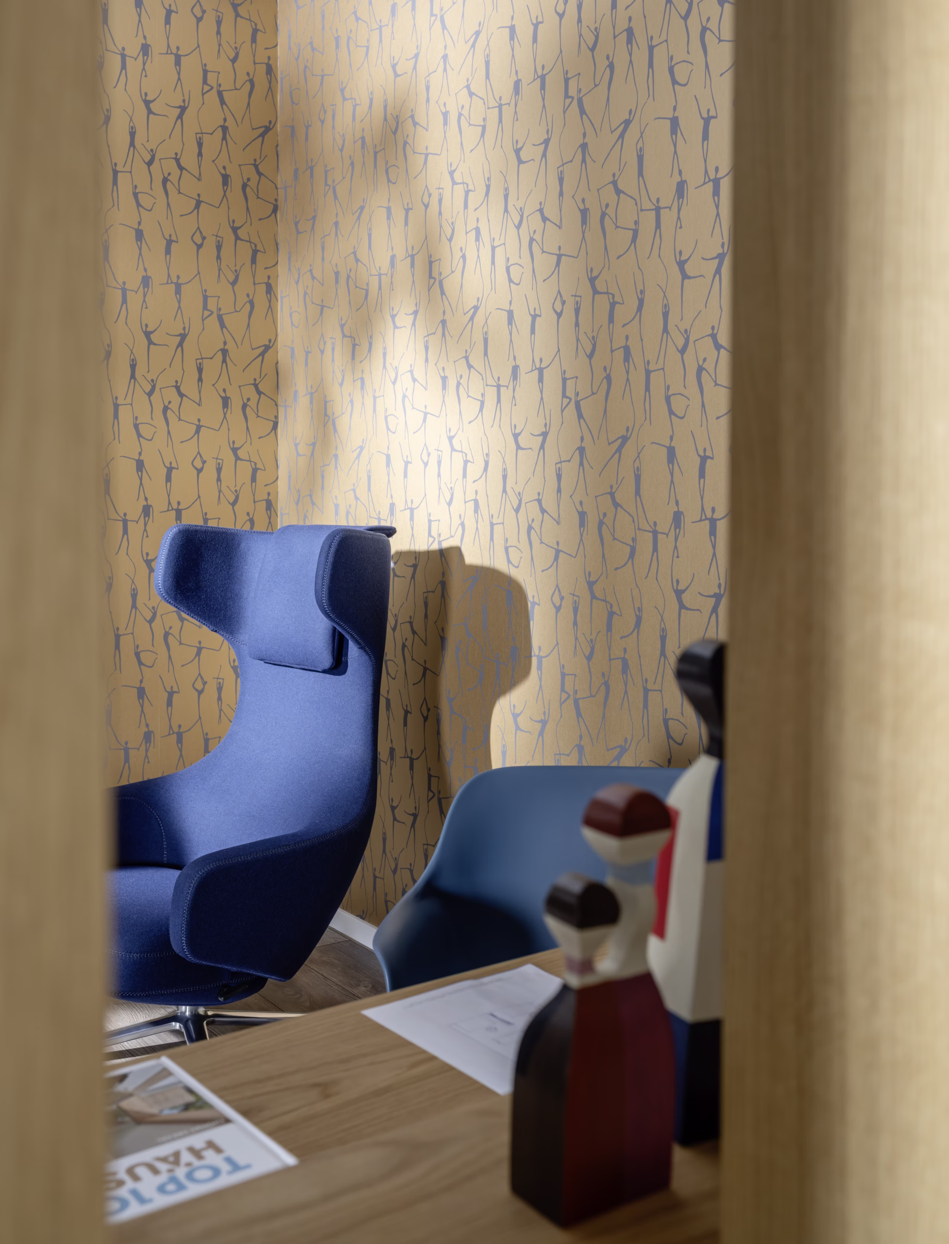 Raum mit strukturierter Wand, Holzmöbeln und blauem Sessel